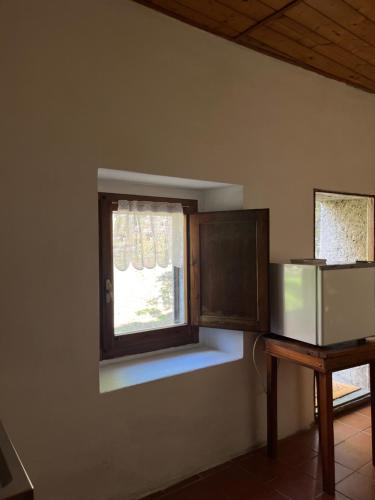Una pequeña ventana en una habitación con una mesa. en Borgo Il Monzone, en Castel dʼAiano