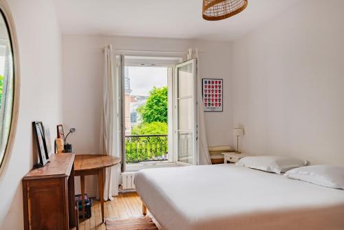 une chambre avec un lit, un bureau et une fenêtre dans l'établissement Paris Porte Maillot Design Residence, à Neuilly-sur-Seine