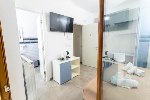 baño con espejo y habitación con lavabo en Gallo's City Rooms en Termoli