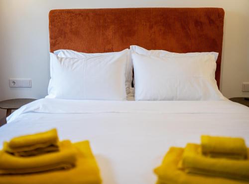 a hotel room with a bed with two yellow towels on it at Bugan-Villa in Athens