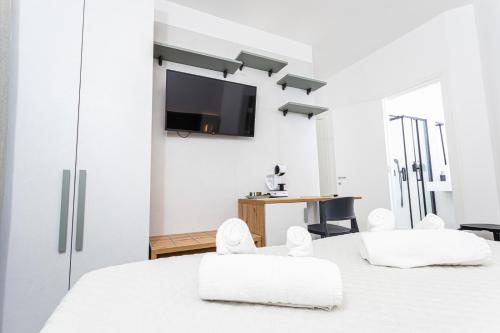 a bedroom with a white bed with two white chairs at Gallo's City Rooms in Termoli