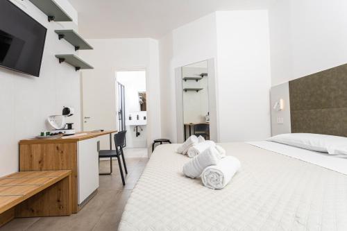 a bedroom with two beds and a desk and a sink at Gallo's City Rooms in Termoli