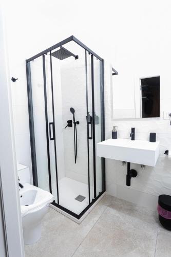 a bathroom with a shower and a sink and a toilet at Gallo's City Rooms in Termoli