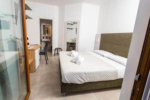 a bedroom with a bed and a desk and a bathroom at Gallo's City Rooms in Termoli