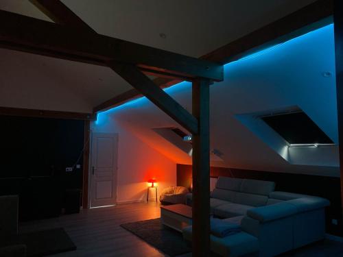 a living room with a couch and a blue light at La Bulle / Jacuzzi, dome et terasse à la campagne in Moussey