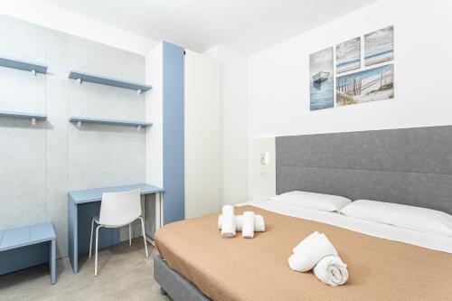 a bedroom with a bed and a desk with towels on it at Gallo's City Rooms in Termoli
