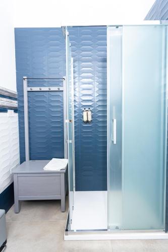 a glass shower with a bench in a bathroom at Gallo's City Rooms in Termoli