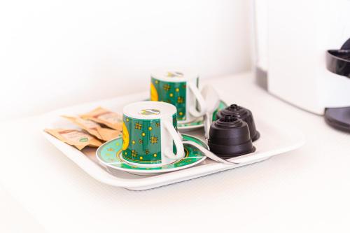 two green and white coffee cups on a plate at Gallo's City Rooms in Termoli