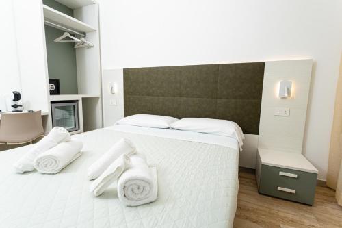 a bedroom with a white bed with towels on it at Gallo's City Rooms in Termoli