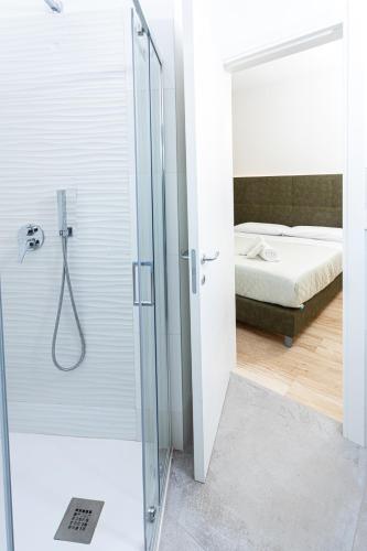 a bathroom with a shower and a bedroom with a bed at Gallo's City Rooms in Termoli