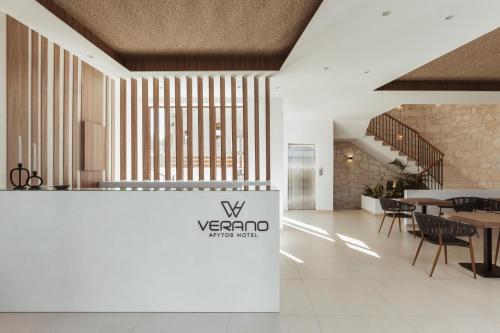 een lobby met een tafel en stoelen en een bord bij Verano Afytos Hotel in Afitos