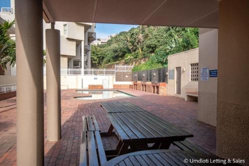 a picnic table and bench on a brick patio at Cozumel 320 in Umdloti