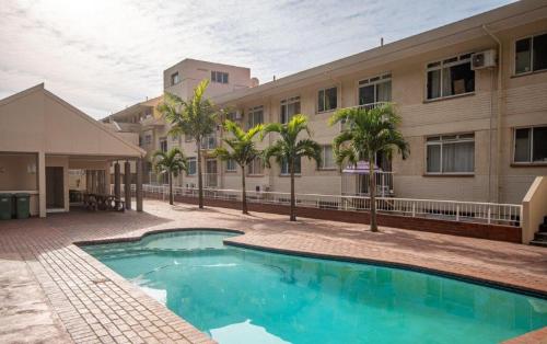 a swimming pool in front of a building at Cozumel 320 in Umdloti