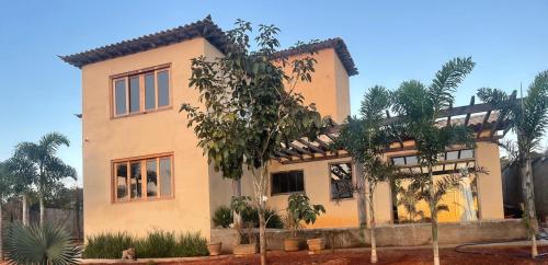 une maison avec des palmiers devant elle dans l'établissement Pousada Canto da Seriema, à Tiradentes