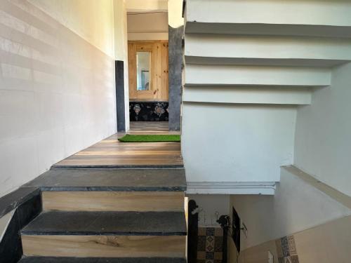 a hallway of a house with stairs and a door at NIRMAN HOMESTAY 5 minutes walk to beach in Puri