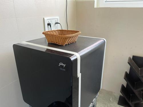 a basket sitting on top of a refrigerator at NIRMAN HOMESTAY 5 minutes walk to beach in Puri