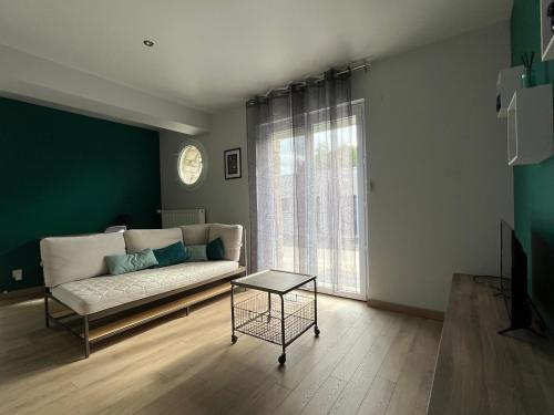 uma sala de estar com um sofá e uma mesa em Appartement proche CHU em Saint-Priest-en-Jarez