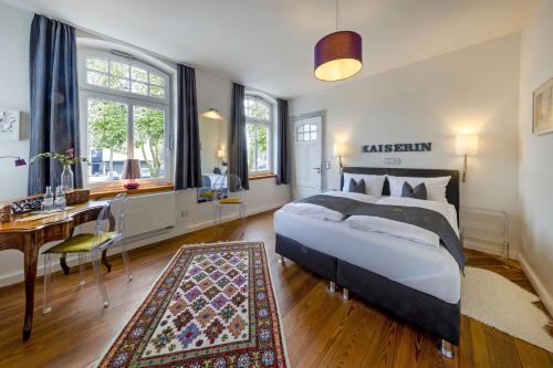 a bedroom with a king sized bed and a desk and a desk at Designhotel 1690 & Apartments in Rendsburg