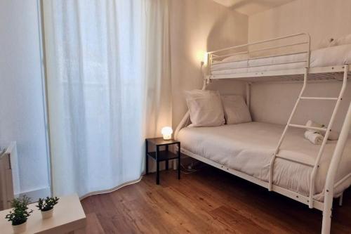 - une petite chambre avec des lits superposés et une table dans l'établissement Marianne Joli T3 Central, Climatisé avec Parking, à Sète