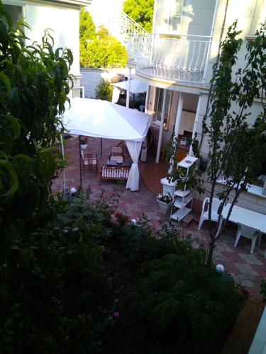 a patio with a white canopy in front of a building at Vilari Odessa in Odesa