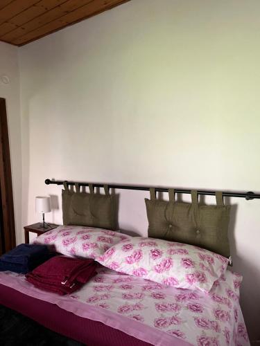 a bedroom with a bed with pink sheets at Borgo Il Monzone in Castel dʼAiano