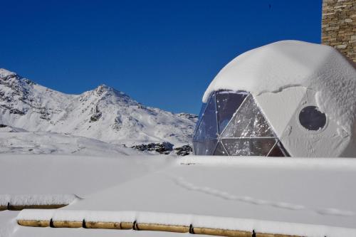 a snow covered igloo in front of a mountain at Hotel Pashmina Le Refuge in Val Thorens