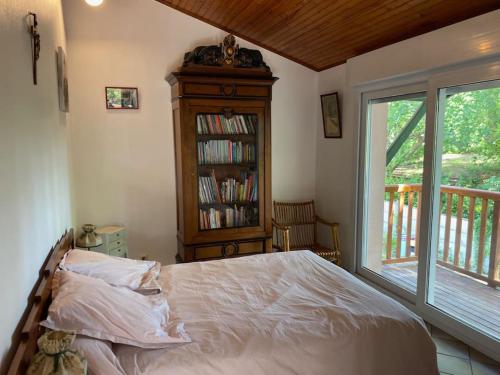 - une chambre avec un lit, une étagère et une fenêtre dans l'établissement Maison familiale dans un grand jardin arboré, à Gujan-Mestras