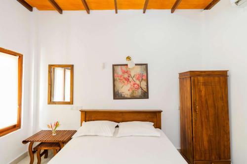 ein Schlafzimmer mit einem weißen Bett und einem Tisch in der Unterkunft Lucas in Bentota