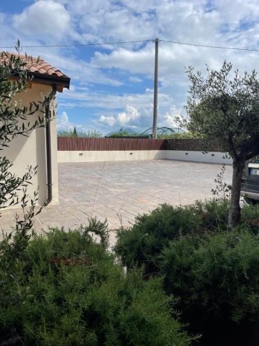 a brick courtyard with a fence and a tree at COTTAGE ILARIO in Lazise