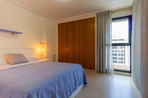 瓦倫西亞的住宿－Alboraya Apartamento con vista al mar y piscina，一间卧室设有一张床和一个大窗户
