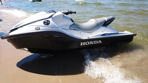a motor boat on the beach in the water at Relax nad Narwią u Oli I Pawła in Pultusk