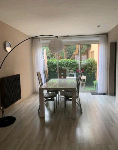 une salle à manger avec une table, des chaises et une lampe dans l'établissement Soleil Bleu, T2, 53 m2 - 15min à pied des plages, au Pradet