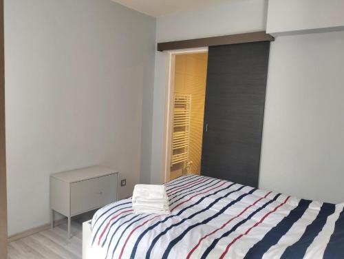 une chambre blanche avec un lit rayé avec une fenêtre dans l'établissement Soleil Bleu, T2, 53 m2 - 15min à pied des plages, au Pradet