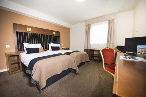 a hotel room with a large bed and a chair at Columba Hotel Inverness by Compass Hospitality in Inverness