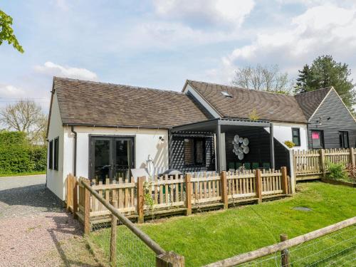 a house with a wooden fence in front of it at The Wood Shed, Bank Top Farm in Ashbourne
