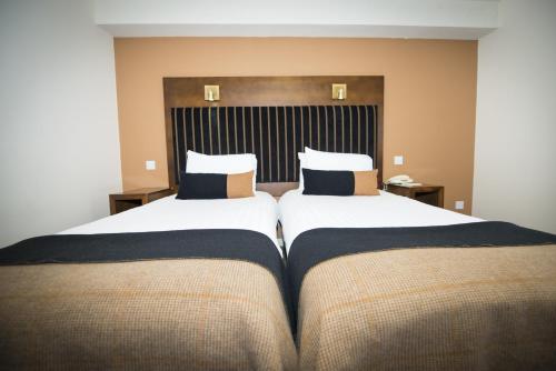 two beds in a hotel room with two pillows at Columba Hotel Inverness by Compass Hospitality in Inverness