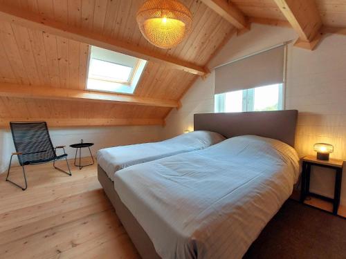 une chambre avec un grand lit dans une pièce avec des plafonds en bois dans l'établissement Groenendijk Verhuur Vakantiehuis Oud Brabers, à Burgh-Haamstede