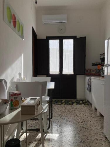 a room with a kitchen with a table and a door at VaNedda in Lentini
