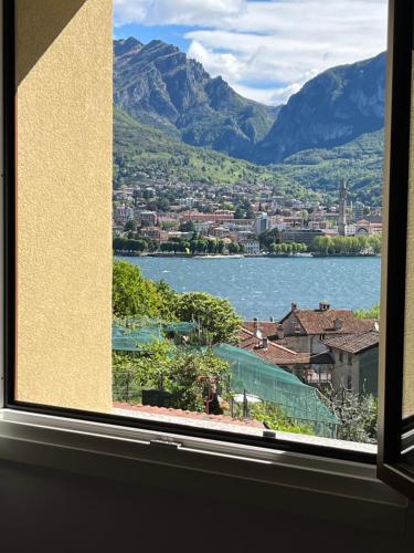 a window with a view of a lake and mountains at Lulù Home in Malgrate