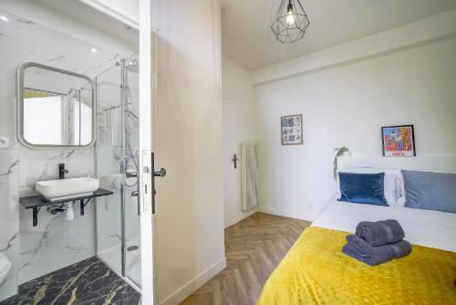 une salle de bain avec un lit, un lavabo et un miroir dans l'établissement Maison Bianchi - Downtown Alsace Lorraine, à Nice