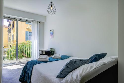 une chambre avec un lit et une grande fenêtre dans l'établissement Maison Bianchi - Downtown Alsace Lorraine, à Nice