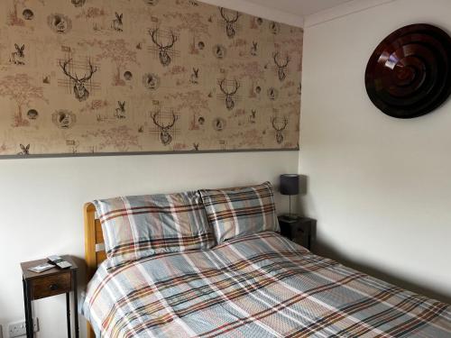 1 dormitorio con 1 cama con manta a cuadros en Exclusive Private double room, en-suite wet room Private entrance en Forres