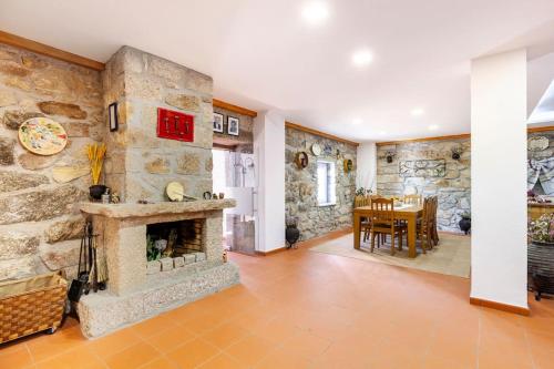 a living room with a stone wall with a fireplace at Casa das Hortênsias in Cerdeira