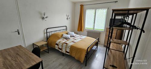 une petite chambre avec un lit et une table dans l'établissement Pavillon avec jardin clos au bord de l'Yonne, à Coulanges-sur-Yonne