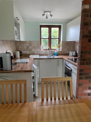 a kitchen with a table and a sink and a counter at Gatekeeper Cottage in Norwich