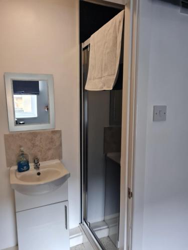 a bathroom with a sink and a shower with a mirror at The Last Post in Blackpool
