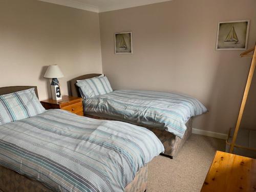 a bedroom with two beds and a lamp in it at Gatekeeper Cottage in Norwich