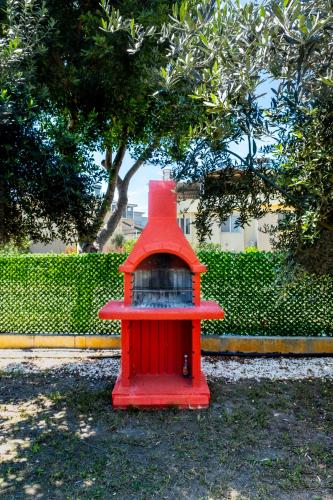a red bird feeder sitting in a park at Efe Tiny House in Serik