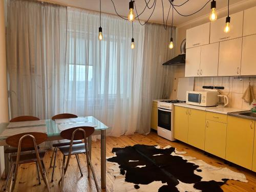 une cuisine avec une table et une cuisine avec un micro-ondes dans l'établissement Квартира в центрі в новобудові Набережний квартал, à Rivne