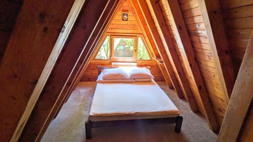 two beds in a small room with a window at VIVA SOLE domek nr 8 in Skorzęcin